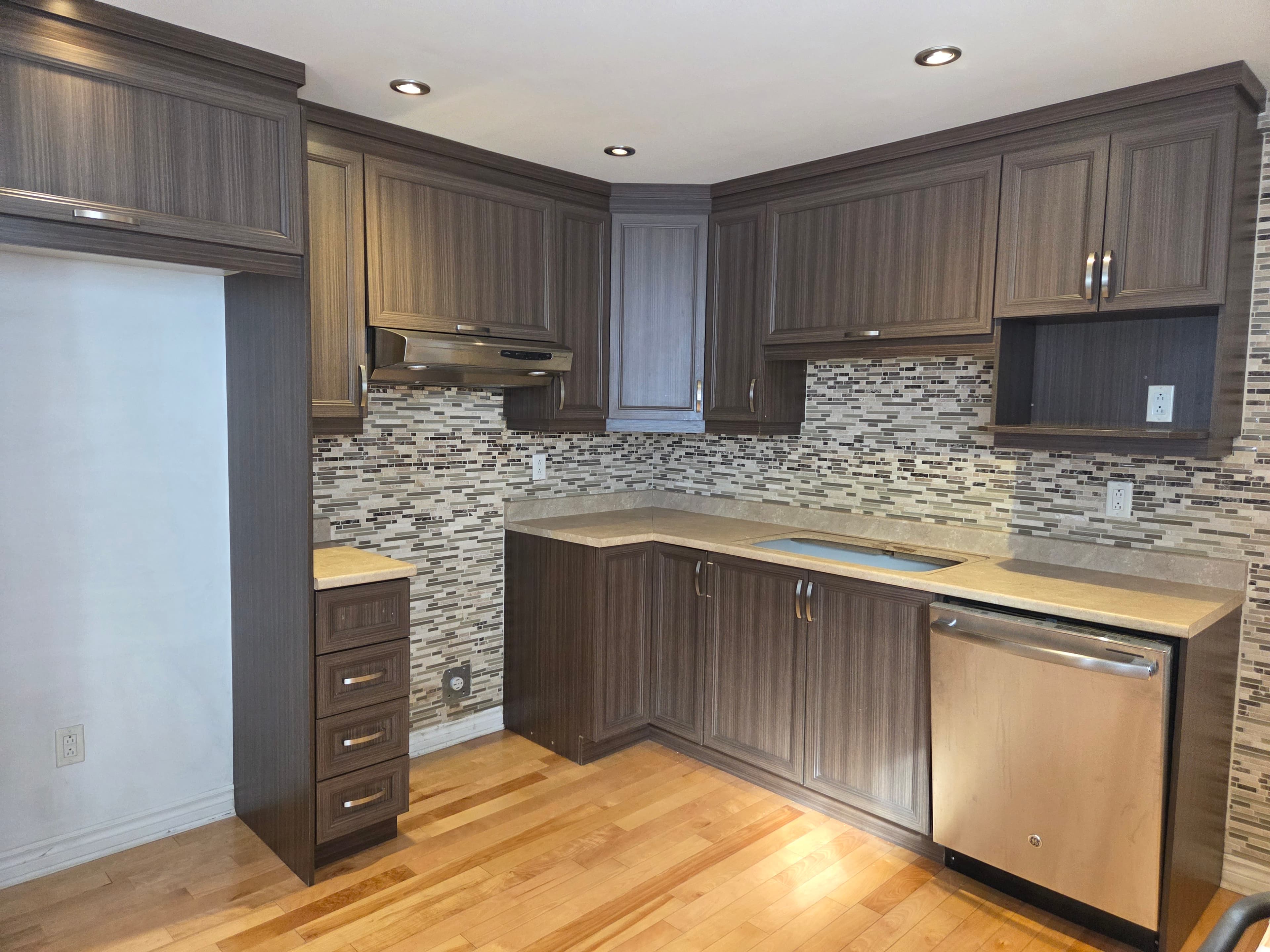 Kitchen with dated wood-grain cabinets before repainting
